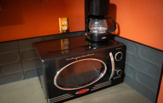 Kitchenette essentials: Microwave and Coffee Maker at Sessions Retreat Hotel.