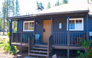 Exterior of Cabin 19 at Sessions Retreat: Front Porch with Blue Table and Chairs, Perfect for Fall Relaxation