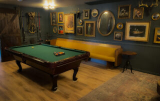 Relax at Sessions Retreat: Vintage Decor, Mirror, and Cozy Couch by the Pool Table Lounge.