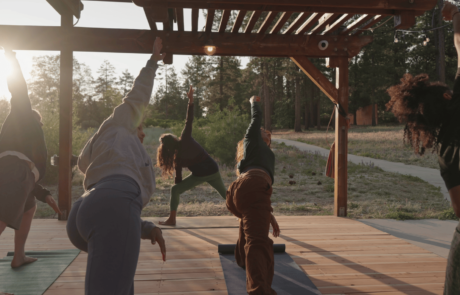 a group of people doing yoga on a wooden deck